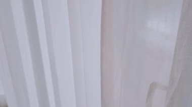 POV, otel odasında dinlenirken adamın elini tutup beyaz perdeyi açar.