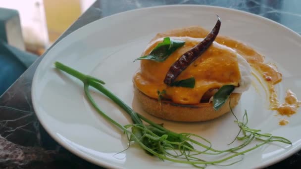 ホランドソースとハムの健康的な食事の朝食のための白い皿の卵ベネディクト — ストック動画