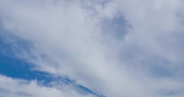 Mavi gökyüzündeki hareket eden bulutun 4k video Zaman Ayarı görüntüsü. Bulutlarla donatılmış güzel bir gökyüzü, bulutlarla ve güneşle mavi gökyüzü, güneş doğarken bulutlar....