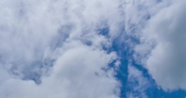 Mavi gökyüzündeki hareket eden bulutun 4k video Zaman Ayarı görüntüsü. Bulutlarla donatılmış güzel bir gökyüzü, bulutlarla ve güneşle mavi gökyüzü, güneş doğarken bulutlar....