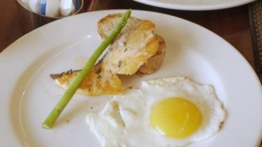 Çatal ve bıçak kullanan bir adam somon bifteği tabağına POV koyarken. Kahvaltı menüsü konsepti