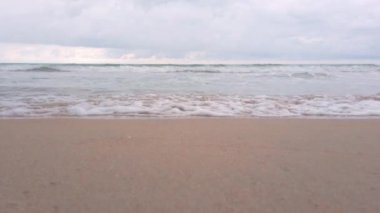 slowmotion of natural sea wave water with foam on the sandy beauty white beach, summer beach seascape