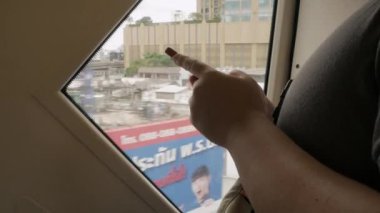 asian man using mobile phone while ride in skytrain public transportation