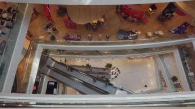 Top down view to escalators in department store with many people shopping
