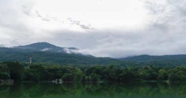 timelapse nature lake with cloud fog moving on the greem mountain hill and forest in winter time, lake time lapse landscape