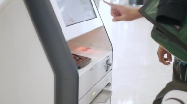 man is checking in with automatic self checkin kios at the airport