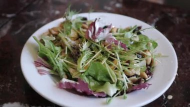 using fork eat fresh salad in white bowl for breakfast