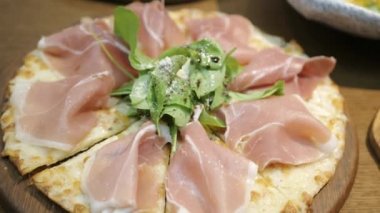 view of a tray of pizza with full of parma ham