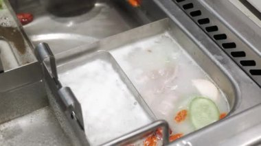 Putting shrimp ball into the Chinese hotpot in sichuan style. Asian hotpot dinning food