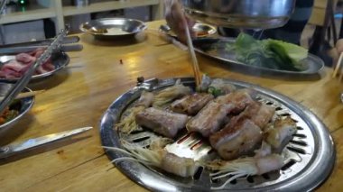 POV to the Korean style BBQ grilled with meat on stove