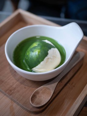 ice cream vanilla flavor with matcha green tea topping in a bowl cup in minimal japanese style cafe