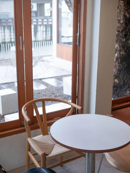 view of empty table with chair inside minimal japanese style cafe near window