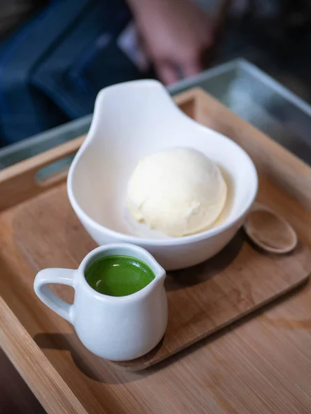 ice cream vanilla flavor with matcha green tea topping in a bowl cup in minimal japanese style cafe