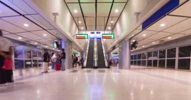 2 Haziran 2022: Bangkok, Tayland: Suvarnabhumi havaalanına gelen ve yürüyen merdiven kullanan yolcuların bulunduğu havaalanı tren terminali içinde zaman ayarlı görüntü. Ülke yeniden açılıyor