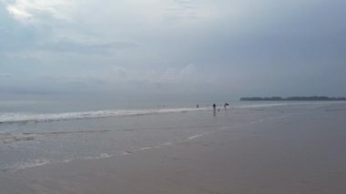 Kumlu beyaz plajda köpüklü doğal deniz dalgası suyu, yaz sahili deniz manzarası.