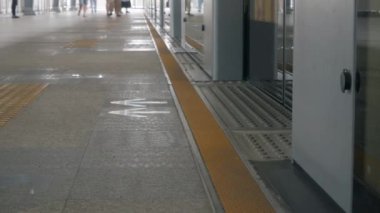 Kapılar açılıp yolcular trenden inerken gökyüzü tren istasyonunun platformuna ayak görüntüsü