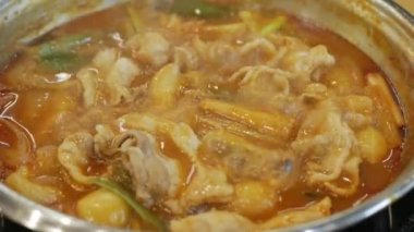 close up to boiling Korean Kimchi tteok pokki soup full with pork and vegetable. Asain korean traditional food