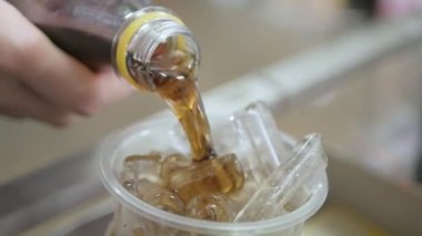 pouring cola soda sparkling refreshment into the glass full with ice. Summer beverage cool drink