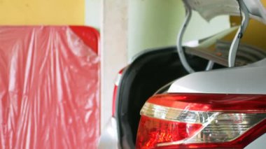 Evin garajında alışveriş yaparken arabanın bagajını kapat.