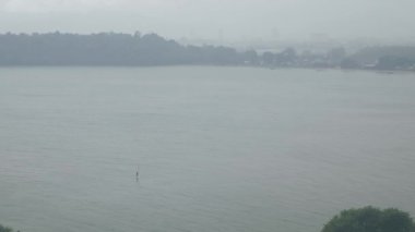 aerial view to a man while sailing in the sea when it is raining in phuket siray bay sea