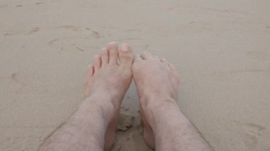 Yaz tatili için Phuket, Tayland 'da sabah erken saatlerde deniz kenarındaki beyaz kumsalda dinlenirken pov' dan yalınayak dolaşmak.