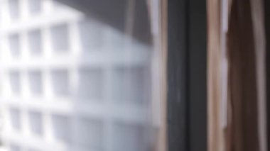 Sabahleyin otel odasındaki büyük pencerenin perdesini kapatırken elin adamının seçici görüntüsü
