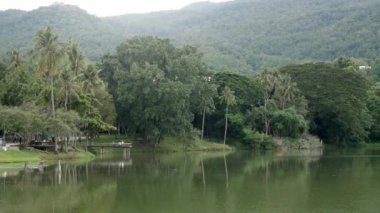 Yeşil dağ sırası ile doğal yeşil rezervuar gölü. Arka planda sis bulutu, Chiang Mai 'de doğal yağmur mevsimi manzarası.