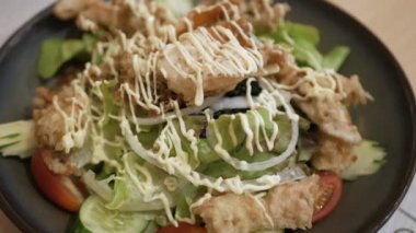 Sebze ve kızarmış yengeç kabuğuyla dolu bir tabak salatanın dönüşümlü görüntüsü. Japon sağlıklı yiyeceği.