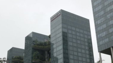 23 Ağustos 2022: Singapur: Metropilis şehrinde fırtınalı yağmur damlası havası ve tropikal yağmurla birlikte Singapur şehrindeki yüksek gökdelenli parkkraliyet oteli kulesine alçak açılı görüş