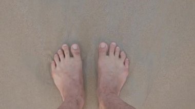 Yaz tatili için Phuket, Tayland 'da sabah erken saatlerde deniz kenarındaki beyaz kumsalda dinlenirken pov' dan yalınayak dolaşmak.