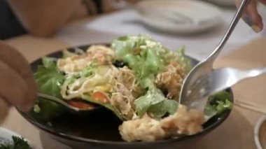 Bir tabak Japon aperatifinden kaşık ve çatal salatası ve kızarmış yumuşak kabuklu yengeç kullanarak.