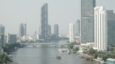 view of Chaophraya River with skyscraper on both shore side of river in the city of bangkok in daytime