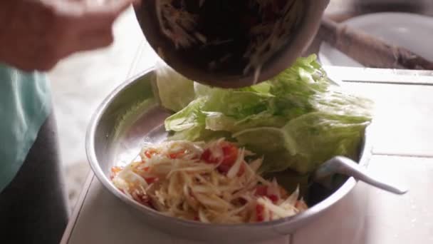 特写镜头时 用大勺从粘土砂浆中挑出木瓜辣沙拉放进大盘里 泰国菜用手 东南亚生活方式食物 — 图库视频影像
