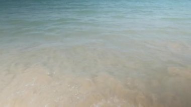 Turkuaz deniz dalgaları, yaz tatili için deniz manzarası olan beyaz kum pürüzsüz plajlara vurur.