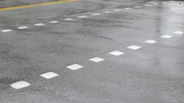 歩行者天国の道路を歩くと 昼間の都市横断線道路に雨を注ぐ 雨滴とアスファルトの道路に選択的な焦点 スタティックカメラ — ストック動画