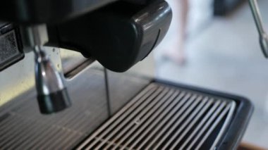 Otomatik kahve makinesine kahve yapmak için bir fincan koy. Kahvaltıda içecek.