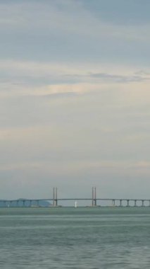 Penang Köprüsü üzerinde Penang adasını birleştiren düşey Timelapse bulutlu güneş ışığı günbatımı gökyüzü saatiyle, Malezya 'nın ünlü simgesi, ulaşım köprüsü