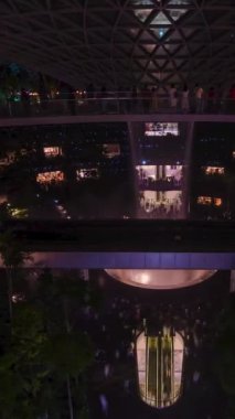 27 Ağustos 2022: Singapur Changi Havalimanı: Jewel Changi 'deki kapalı şelalenin dikey zaman çizelgesi ve Jewel' de ışık saçan, kapalı bir tropikal yağmur ormanı olan bir girdap şelalesi