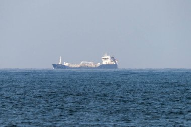 Beyaz dumanlı ve mavi arkaplanlı büyük bir gemi tankeri..