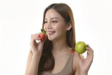 Beyaz arka planda elma ve çilekli güzel Asyalı kadın..