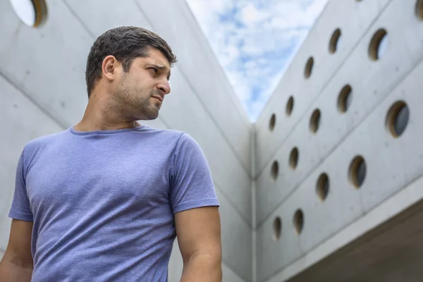 Человек на фоне современного бетонного здания — стоковое фото