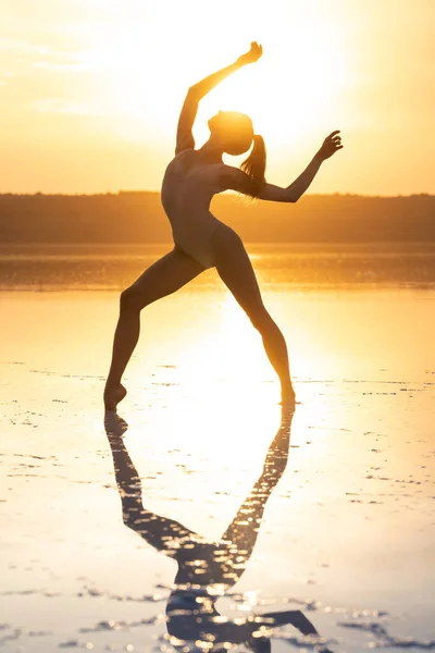 Ballerina di danza femminile è in posa in laguna di fronte al sole splendente cielo — Foto Stock