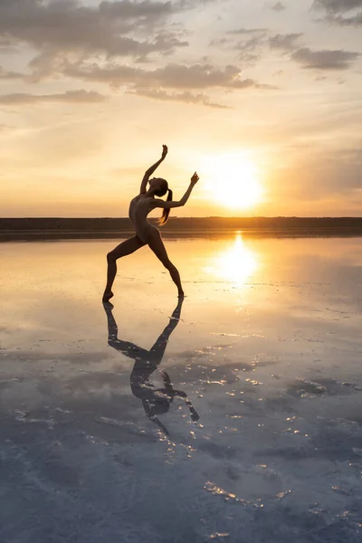 Γυναίκα χορεύτρια μπαλέτου ποζάρει στη λιμνοθάλασσα σε φόντο χαμηλού ήλιου — Φωτογραφία Αρχείου