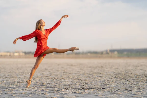 Ballerina di balletto femminile sta posando sulla spiaggia di sale soleggiata — Foto Stock