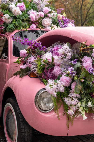 Çiçeklerle doldurulmuş ve süslemeye dönüştürülmüş klasik renkli otomobil — Stok fotoğraf