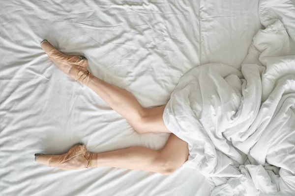 Mujer en zapatos puntiagudos muestra sus piernas desde debajo de la cubierta — Foto de Stock