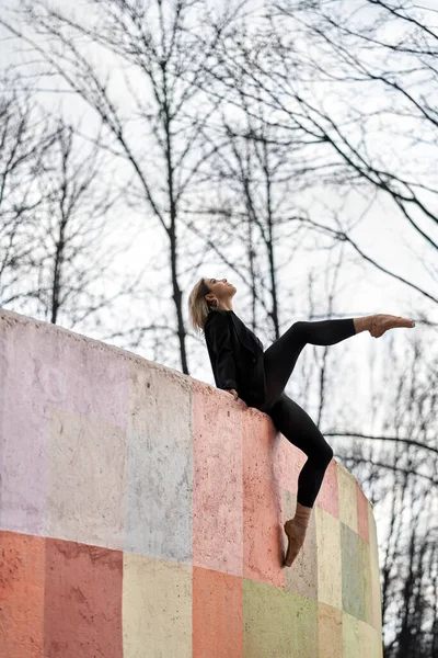 Blondýnka baletní tanečnice pózující na barevné stěně — Stock fotografie