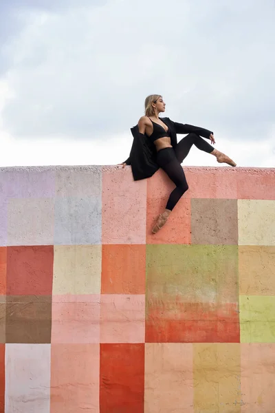 Blondýnka baletní tanečnice pózující na barevné stěně — Stock fotografie