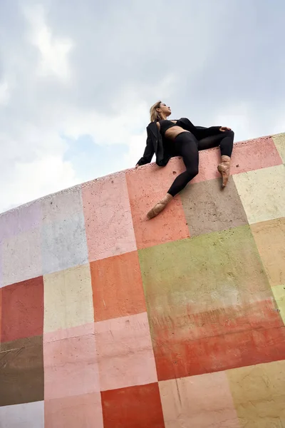 Blondýnka baletní tanečnice pózující na barevné stěně — Stock fotografie