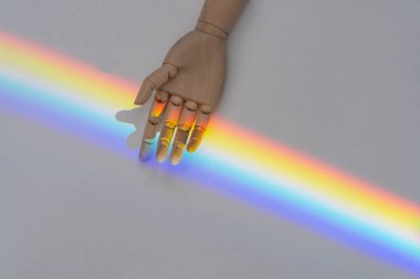 LGBT topluluğunun arka planında beyaz bir arka plan ve ahşap bir el var. LGBT toplum desteği ve hoşgörü kavramı